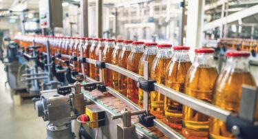 Conveyor belt in manufacturing plant with juice in glass bottles