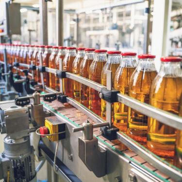 Conveyor belt with juice in glass bottles