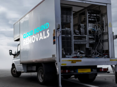 A van filled with legacy infrastructure driving towards the cloud.